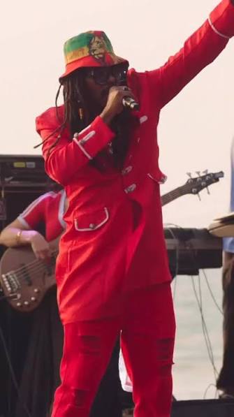 Anthony Locks performing live, arm raised with microphone